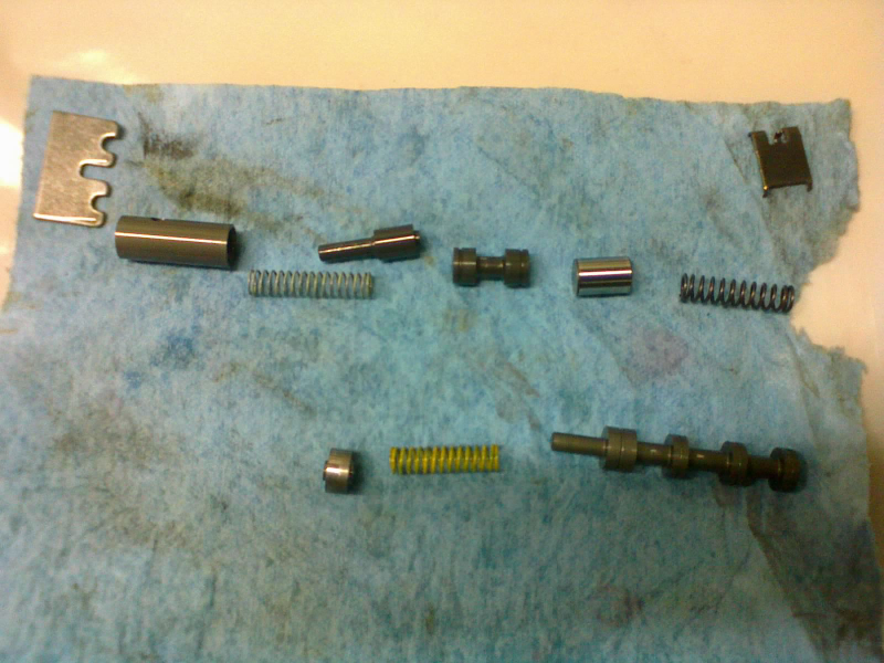 TOP: torque converter clutch valve. BOTTOM: T/C control valve. Both valves are held in by the large retainer on the top left. The one on the top right retains part of the TC clutch valve, and is installed before the rest of that valve is assembled.